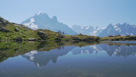 gente caminando por el lac blanc con reflejos de las montañas, en el valle de chamonix, en francia en un día soleado