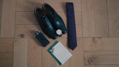 elegant shoes tie watch and invite styled flat on wooden surface