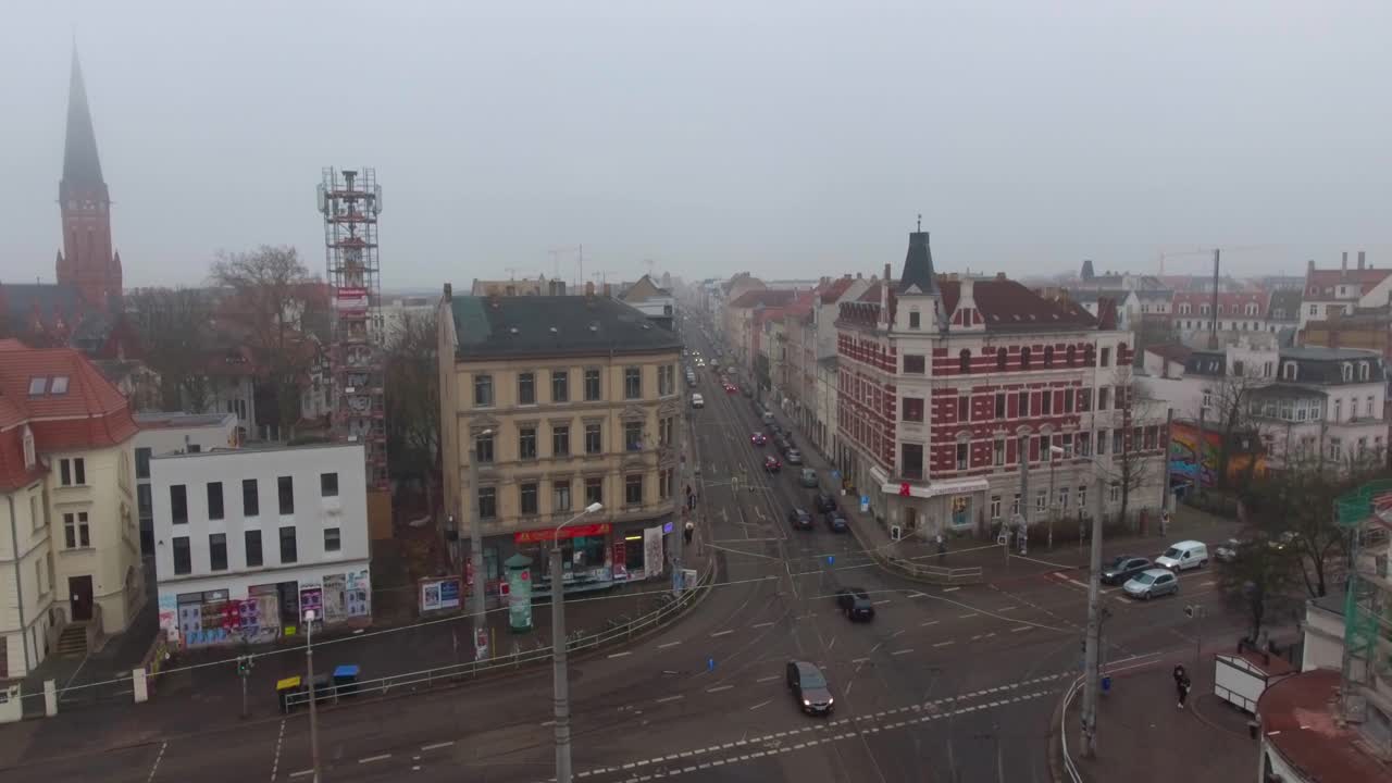 Traffic on a Crossroad in Leipzig, Germany on a misty day. 4K Pan Right Aerial Drone Shot.