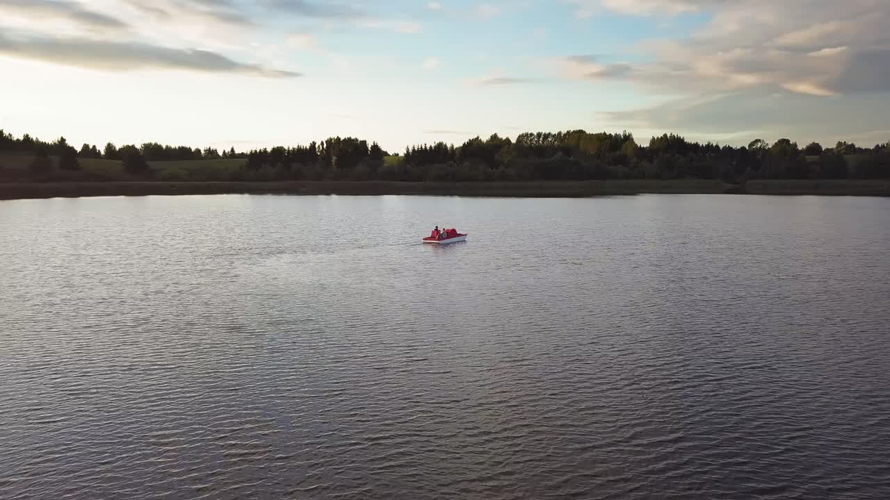 Family on a Pedal Boat on a Lake at Sunset Drone Shot