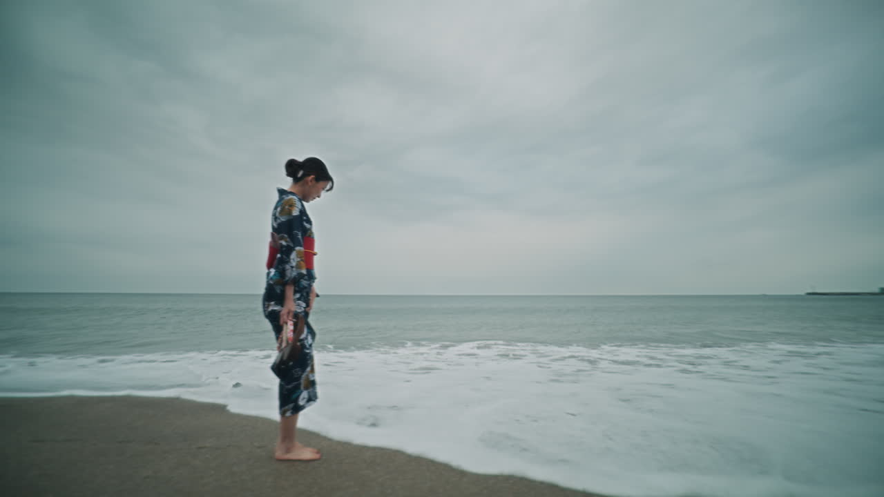 Woman in Kimono Walking on Beach