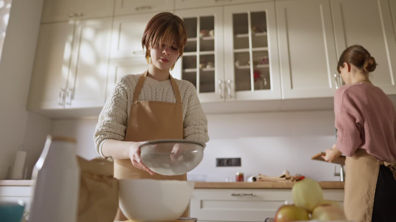 Mother and Daughter Cooking in Kitchen