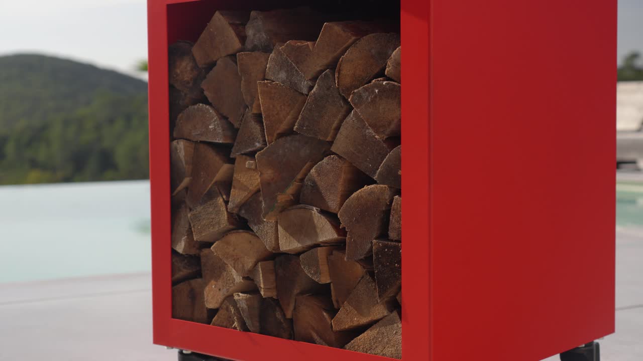 freshly cut firelogs tacked in a container to dr out before use beside a pool