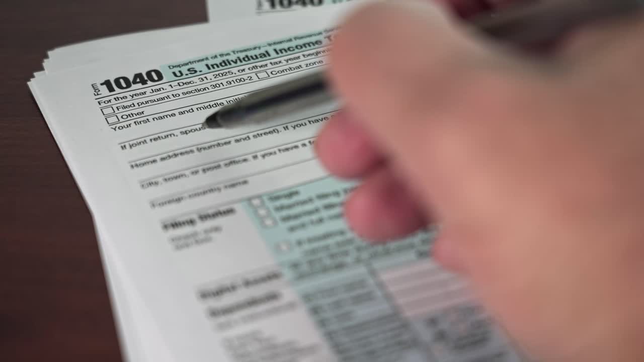 Una persona sta compilando il modulo 1040 per le imposte sul reddito individuali per l'anno 2025. Il documento mostra le informazioni personali e finanziarie necessarie per la dichiarazione dei redditi.