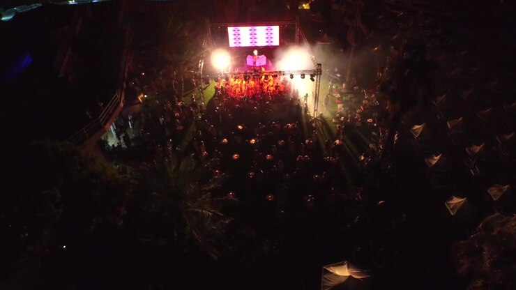 Vista aerea di una festa in discoteca all'aperto con DJ e folla che balla