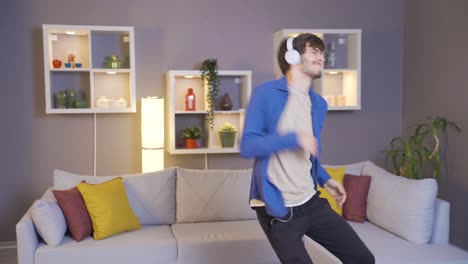 happy young man in headphones and listens to music from music app and dances.