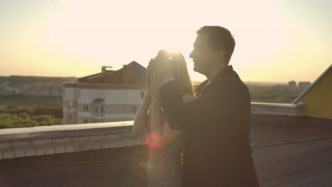 lovers man and woman married couple young come to the edge of the roof! and lovingly look at each other and hug.