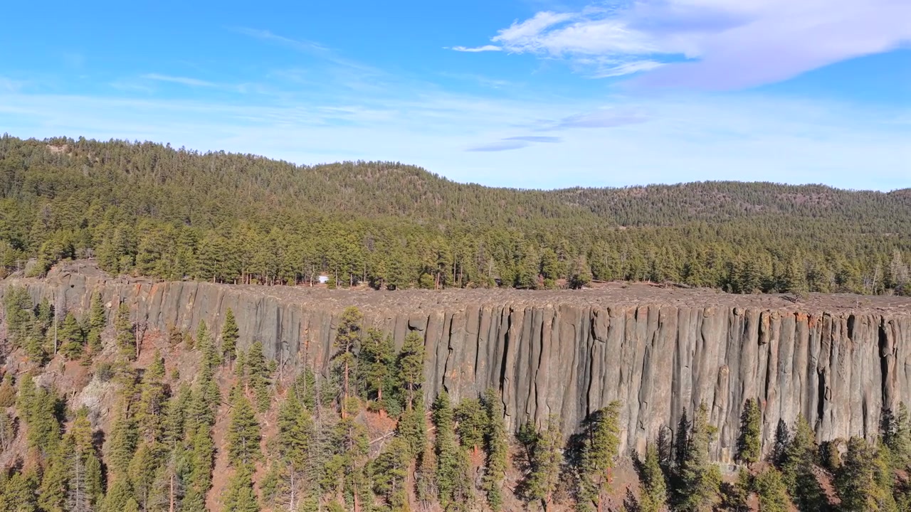 4K-ilmakuvaus, joka esittelee jyrkän magmakiviseinämän monimutkaista geologiaa. Kohoavat harmaat basalttipylväät muodostavat dramaattisen geologisen rajan, jota ympäröi lounainen mäntymetsäympäristö