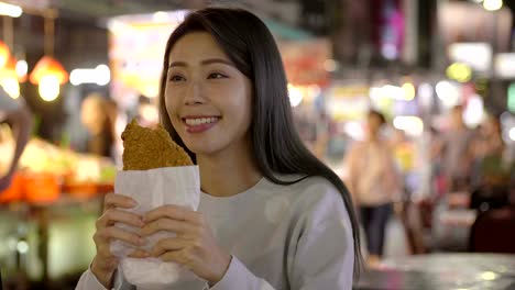 asian woman enjoy  chicken fillet with street food in  night market