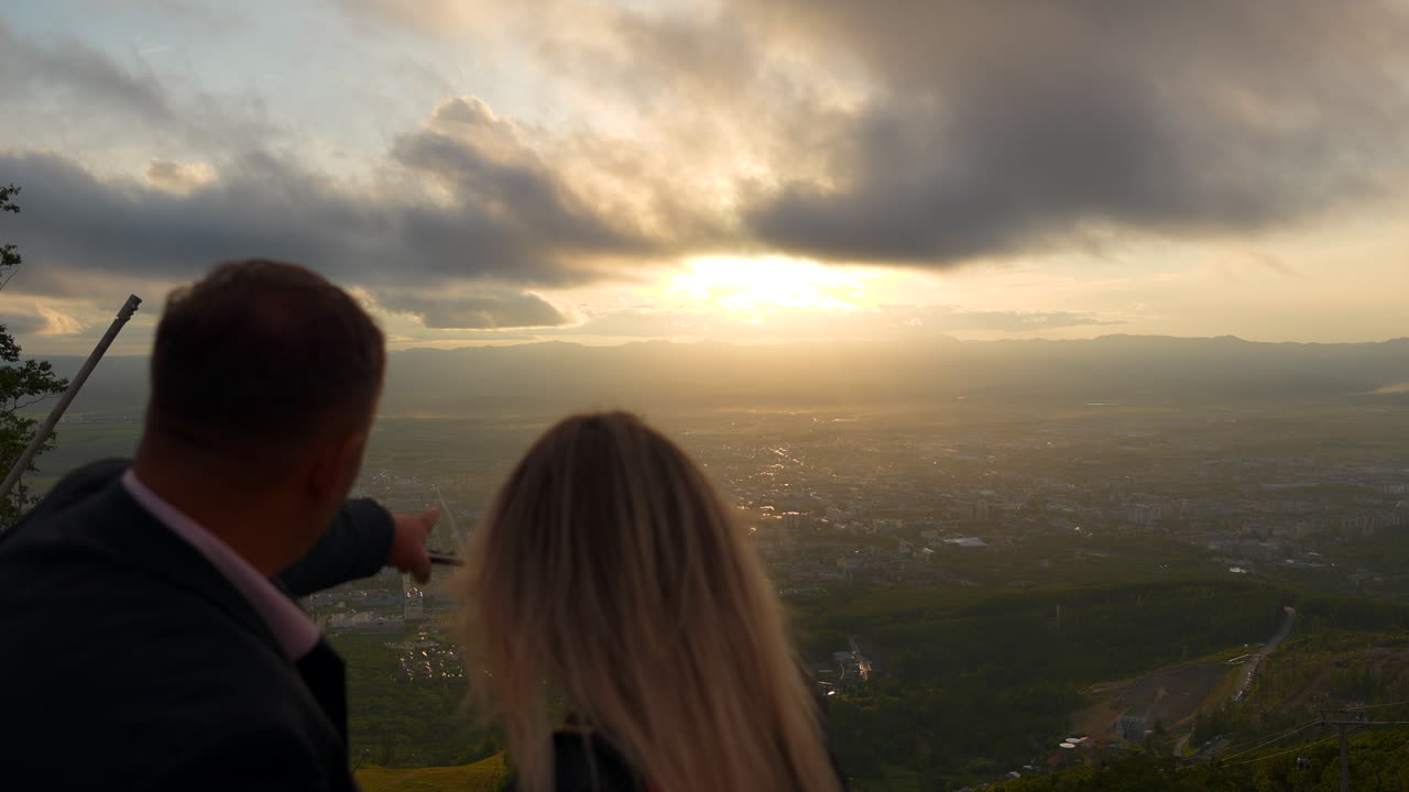 vista del atardecer desde la cima de la montaña con una pareja