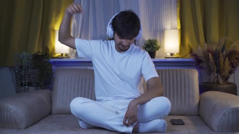 man dancing at night while listening to music at home.