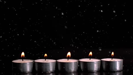 Animation-of-dust-falling-over-tealights-on-black-background