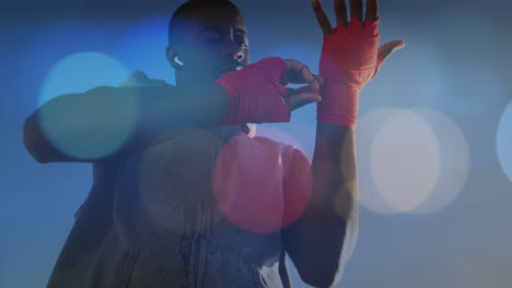 puntos coloridos de luz contra el boxeador afroamericano aplicando cinta de esclavitud en las manos