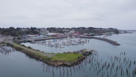 Descending-aerial-dolly-over-pier-and-dock-at-high-tide-showcasing-fishing-boats