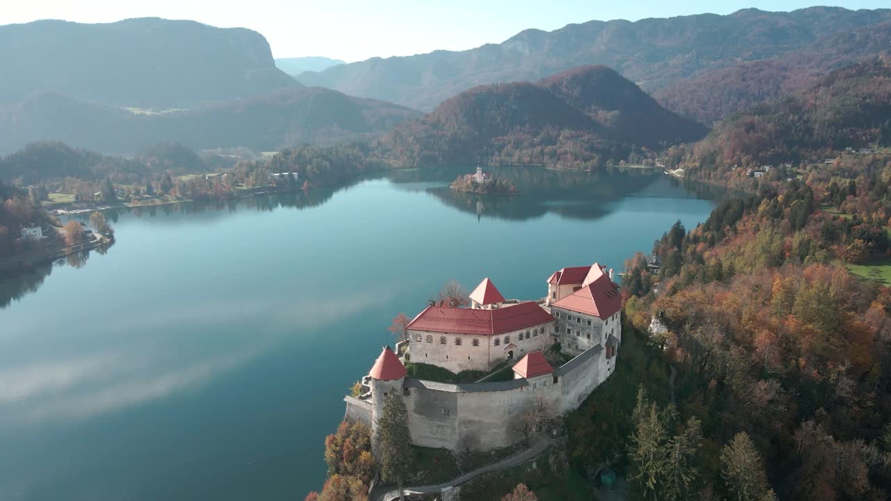 Splendida carrellata aerea che domina il castello sulla scogliera del Lago di Bled, Slovenia, in una giornata di sole.