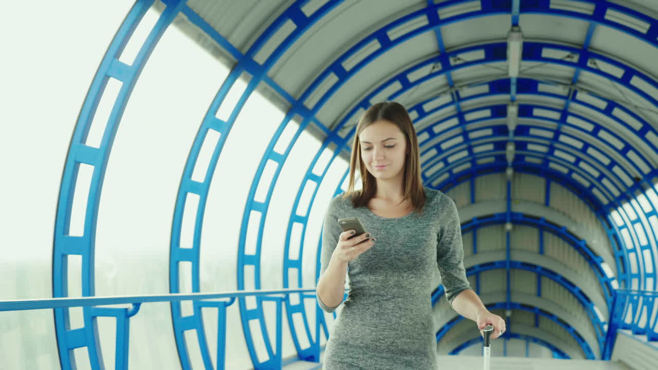 여행 가방을 든 젊은 비즈니스 우먼이 터미널에 도착합니다.