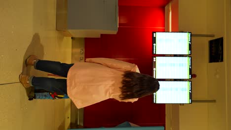 woman ready to start a trip looking for her departure gate in the flight panels at dublin airport