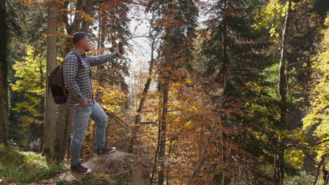 man taking a picture in a beautiful autumn forest