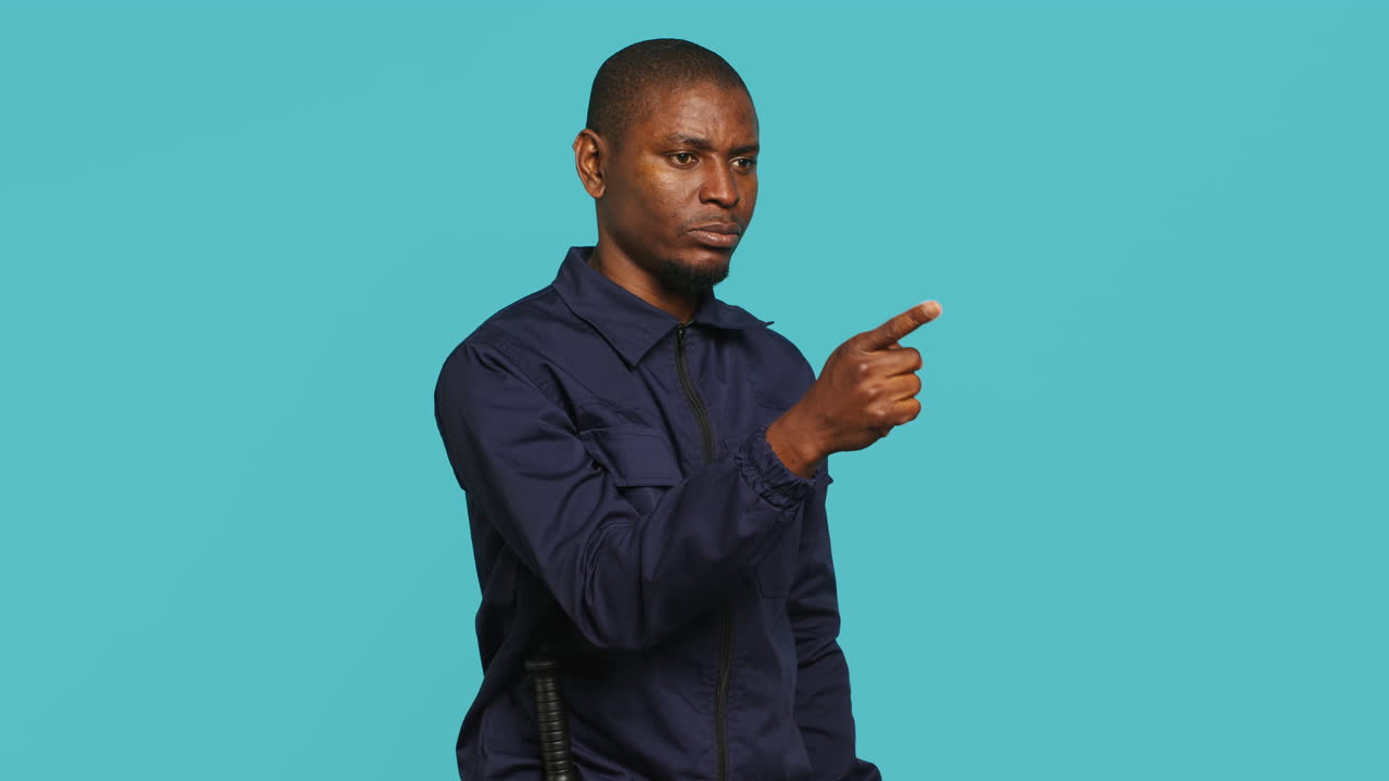 Portrait of security guard pointing finger at intruder while overseeing premises