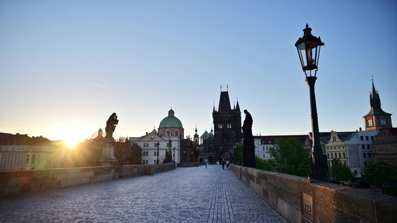 Il selciato vuoto del Ponte Carlo all'alba, con statue in silhouette e la Torre del Ponte della Città Vecchia davanti, Praga, Repubblica Ceca