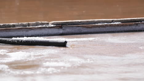 water flows from a hose to salt pans at rio maior in portugal