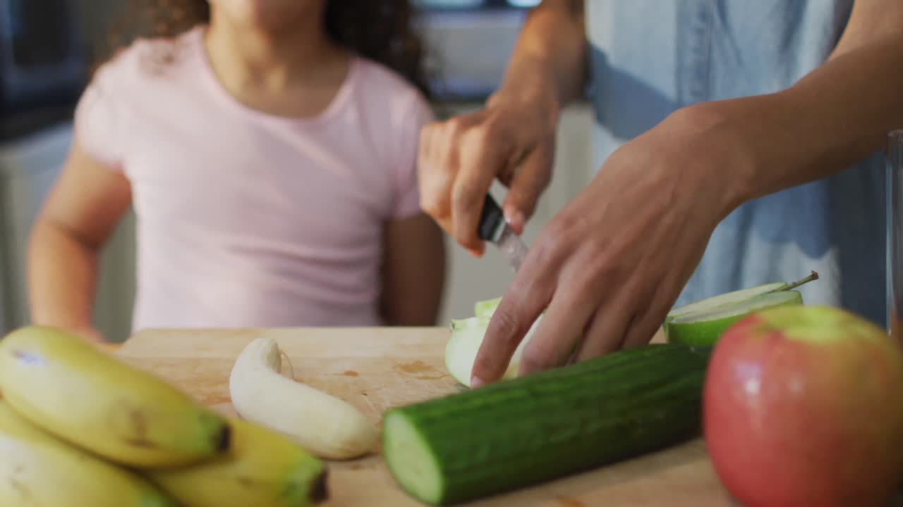 Mixed race mother and daughter cooking together in the kitchen