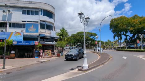 street view of busy traffic on roads in capital city of papeete on tropical island of tahiti in french polynesia, south pacific