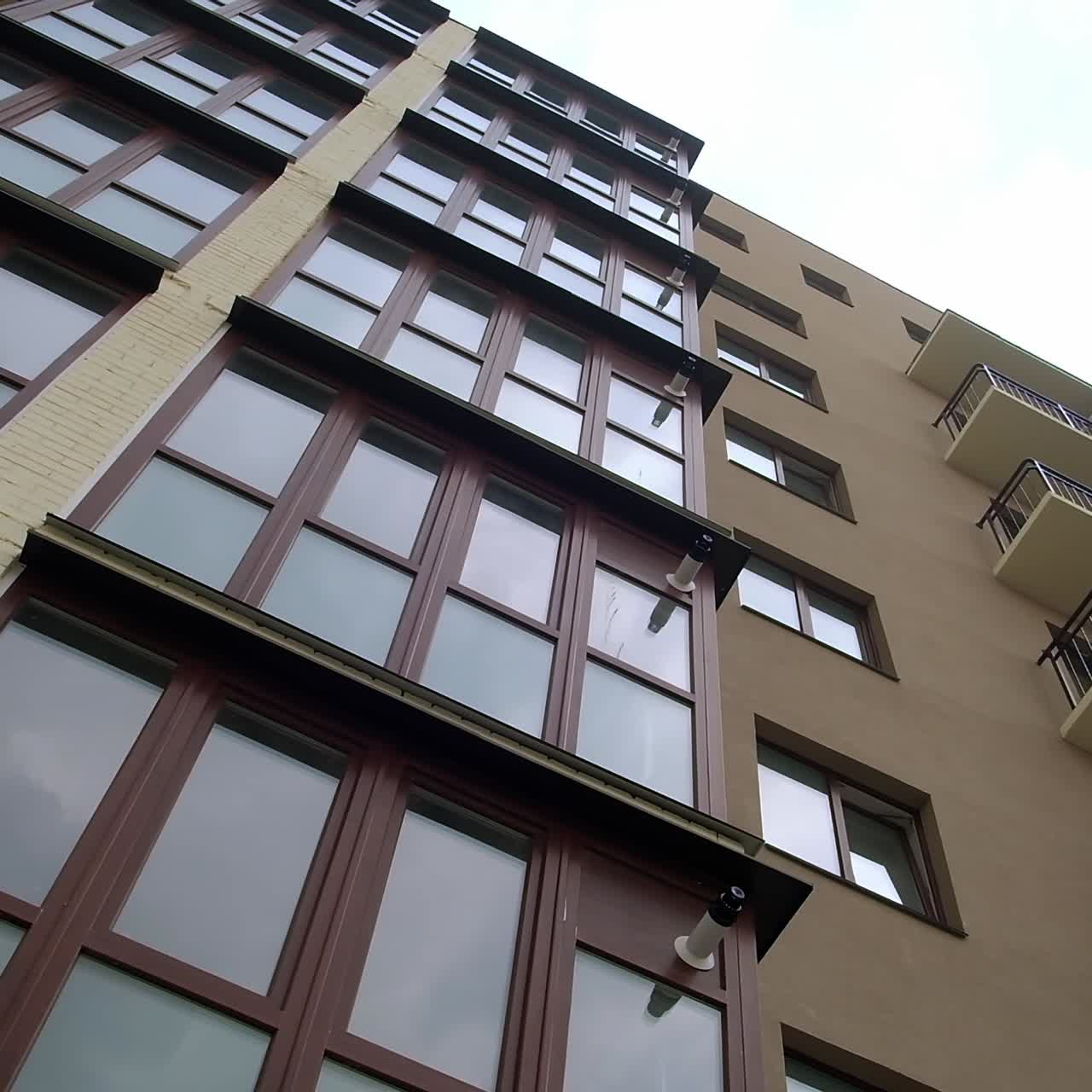 Looking at the exterior of the recently built apartment building. Multi-storied residential house from low angle perspective