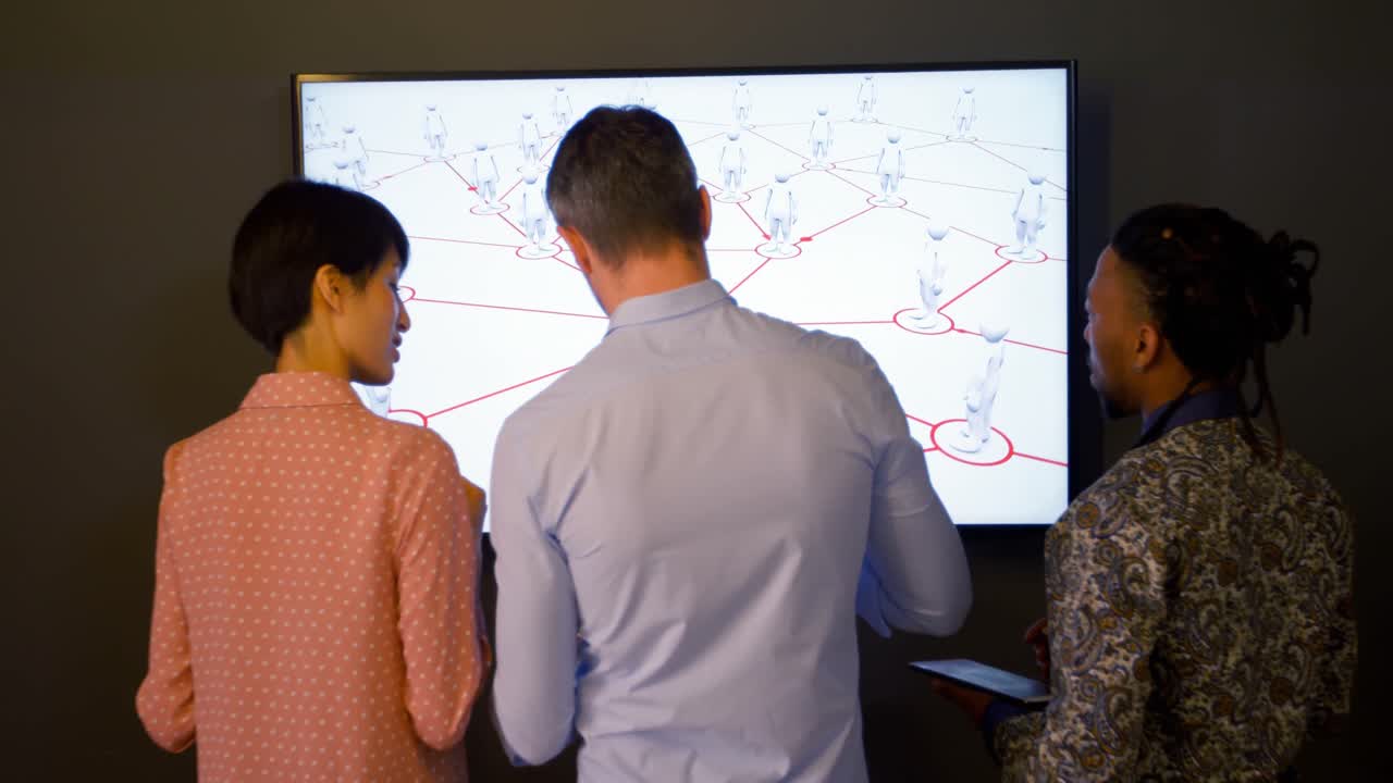 vista trasera de un colega de negocios discutiendo sobre una pantalla digital 4k