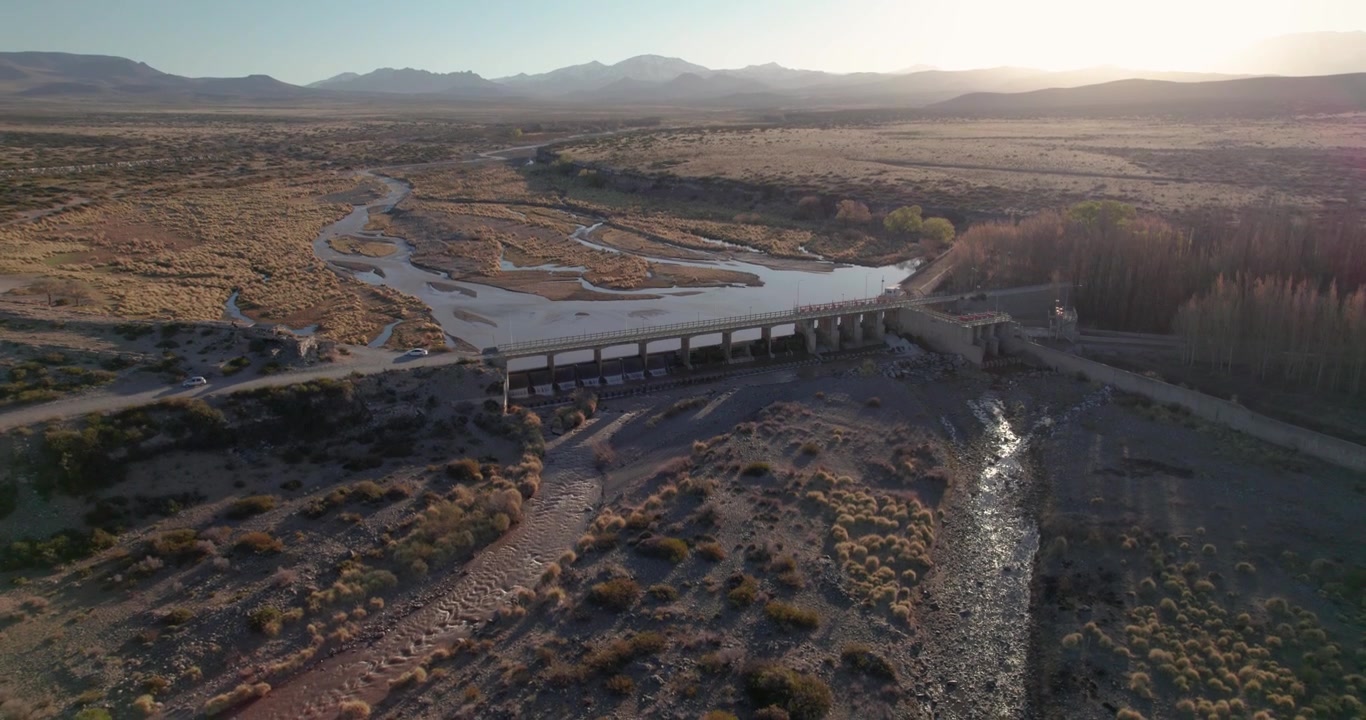 Arid Malargüe landscape concrete dam over river distant Andes mountains