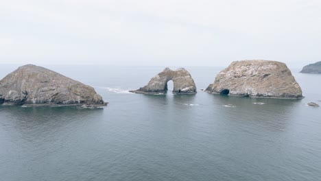aerial view of the oregon coast, with craggy cliffs and crashing waves