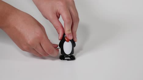 hands wind up a penguin toy