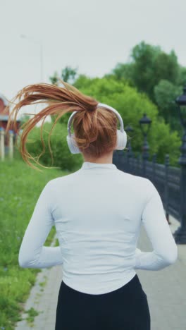 a young person jogging with headphones along a scenic path, enjoying music while getting fit outdoors, capturing a moment of exercise and vitality