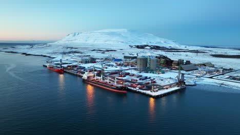 Hermosa-Toma-Aérea-De-Drones-Del-Puerto-De-Carga-Elkem-Thamshavn-En-Un-Paisaje-De-Invierno-Blanco-Después-Del-Atardecer