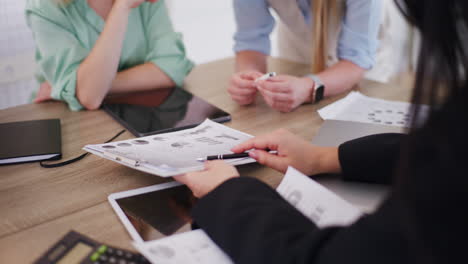 three businesswomen analyze sales report during meeting