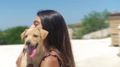 close up of happy female and adorable kokoni dog puppy in her arms on summer day full frame