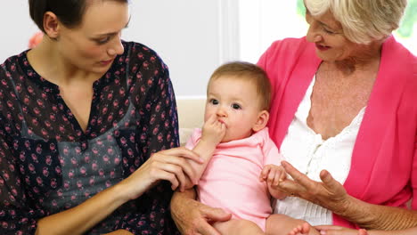 niñas de la familia sentadas en el sofá con el bebé