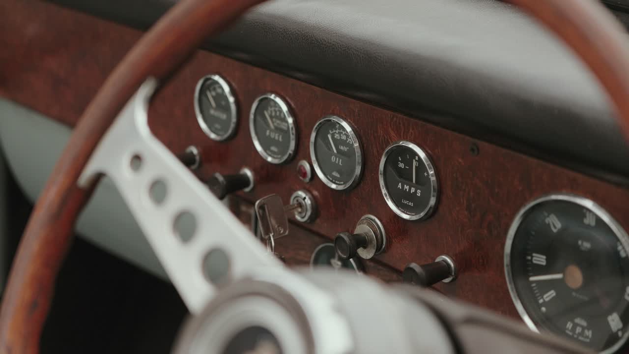 Close up of retro car interior showing wooden panel and gauges