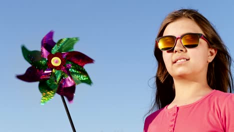 una niña encantadora con un juguete de molino de viento