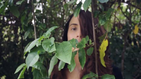 woman hiding behind foliage