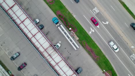 top down aerial of tanker semi truck delivering fuel to the gas stations pumps