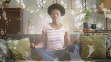 Animation of leaves and light spots over african american woman meditating, slow motion