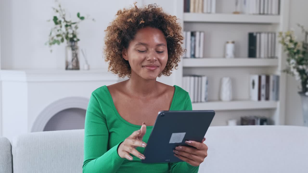 Young happy ethnic african american woman using tablet computer for video call