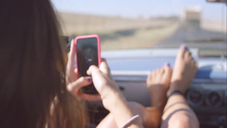 Schönes-Mädchen,-Das-Auf-Einem-Roadtrip-In-Einem-Cabrio-Oldtimer-Fotos-Mit-Dem-Smartphone-Macht