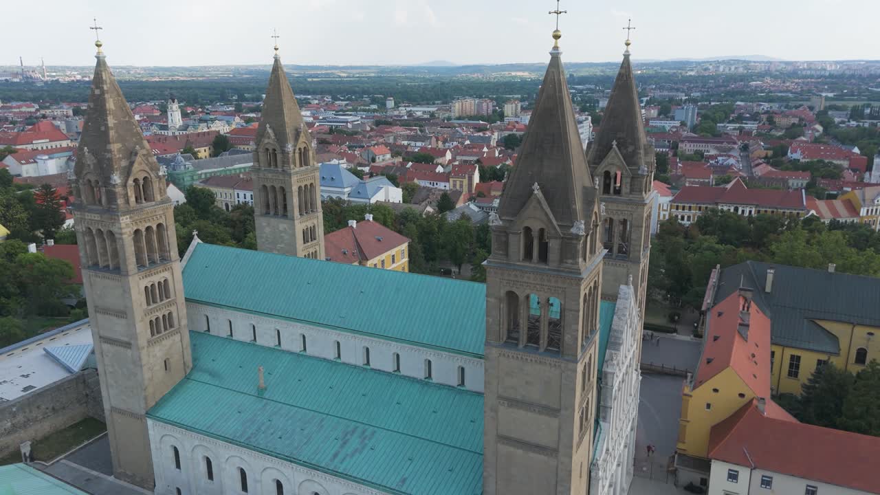 Scenic pullback from Pécs Cathedral, highlighting its towers, rooftops, and historic city backdrop
