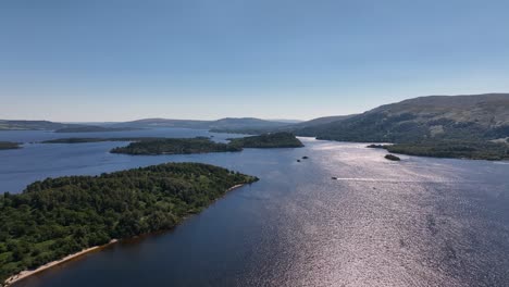 Sonniger-Tag-Auf-Loch-Lomond,-Der-über-Inseln-Fliegt,-Mit-Booten,-Die-Kurz-Unterwegs-Sind