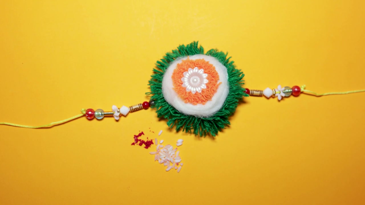 Rakhi tradizionale di Raksha Bandhan isolato con chicchi di riso e polvere di kumkum.