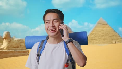 tourist talking on phone near pyramids