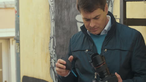 photographer cleaning camera with lens blower