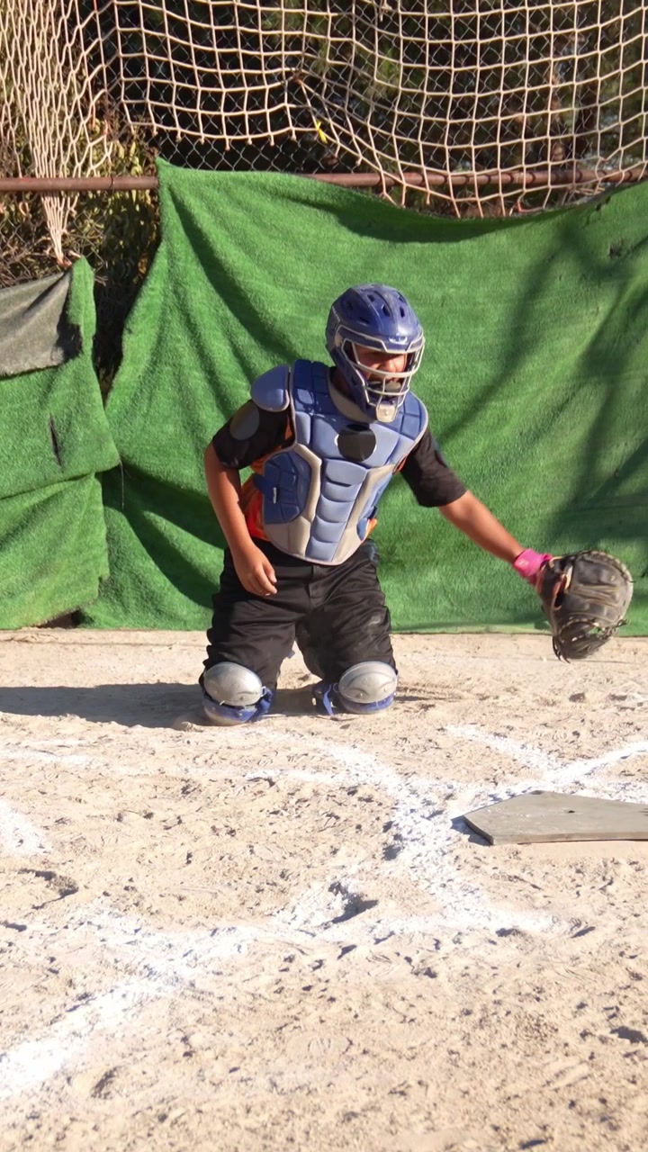 Giovane ricevitore di baseball si allena nella posizione difensiva sul campo